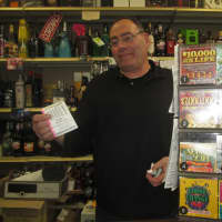 <p>Lewis Stern holds up a Powerball ticket at Yorktown Wine and Liquors.</p>