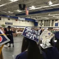 <p>Students have fun with their mortarboards at the Staples High graduation.</p>