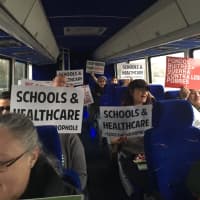 <p>The protesters — with signs in hand — ride a bus from Bridgeport to Greenwich on Saturday.</p>