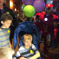 <p>Gavin Cheski, 7, of Elmwood Park takes his first seat in his new stroller donated to him Sunday.</p>