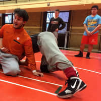 <p>First-year Dumont wrestling coach Mike Rooney works through new skills with senior Mike Vietri.</p>