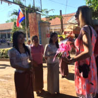 <p>Cathy Zahn is given flowers by Cambodians.</p>
