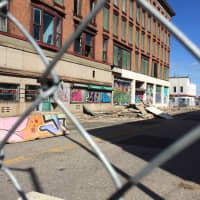 <p>Piles of rubble sit in front of a vacant building on a closed street near the corner of Main and Golden Hill streets in Bridgeport.</p>
