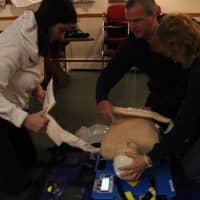<p>Volunteers learn how to use an Auto-Pulse, a device used to give compressions to patients automatically.</p>