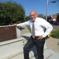 <p>Harrison Mayor Ron Belmont stands next to the base of World War I monument in Ma Riis Park. The zinc statue broke at the ankles and shattered after being toppled by strong winds in June. It has been replaced with a bronze version.</p>