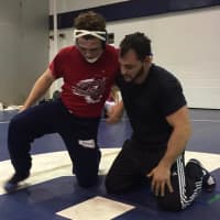 <p>Bonino and Paramus wrestling coach Chris Falato work through moves on the mat.</p>