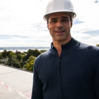 <p>Time Hotel General Manager Christopher Costabile on unfinished roof deck in hard hat. Deck has view of Hudson River and Tappen Zee Bridge</p>