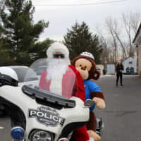 <p>Closter Police Officer Justin Krapels takes a Paramus teddy bear for a spin.</p>