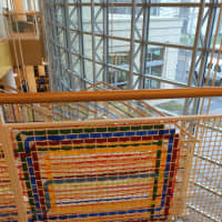 <p>Artist Katherine Daniels created an art installation of colorful plastic strips woven into the gridded surround of Greenwich Library&#x27;s grand stairs.</p>