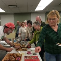 <p>Chef&#x27;s Table fans sample some of Richard Herzfeld&#x27;s fresh breads, bagels and cookies at Fairfield Public Library.</p>