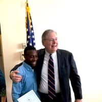<p>Kashawn Caleb Beatty with a proclamation after the 19-year-old came to the aid of a friend in need. Beatty is shown with Stamford Mayor David Martin.</p>