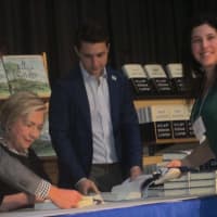 <p>Hillary Clinton signs a book for Laura Schaefer at the Chappaqua Library.</p>
