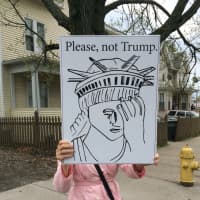 <p>A woman holds a handmade protest sign outside a Trump rally at the Klein Memorial Auditorium in Bridgeport.</p>