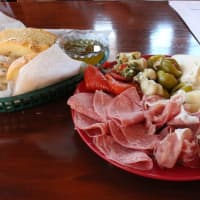 <p>Three different types of bread on the left, an assortment of meats, cheeses and vegetables on the right.</p>