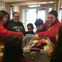 <p>Sacred Heart University students Jacqueline Passariello, left, and Maggie Hayes, right, show some of the books they donated to Madison Elementary School in Bridgeport.</p>