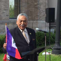 <p>State Sen. Ed Gomes of Bridgeport waves the Haitian flag at a Haitian Flag Day ceremony Wednesday.</p>