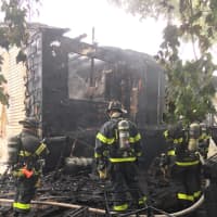 <p>Firefighters battle a structure fire at a house in Norwalk, the result of lighting, according to the Norwalk Fire Department.</p>
