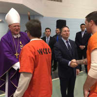 <p>Cardinal Dolan and County Executive Astorino greet prisoners after the Mass service.</p>