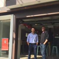 <p>Brenan Hefner, left, and Clayton Bushong, right, partners in Cantinas Lobos in Pelham, stand by the  eatery&#x27;s garage door.</p>