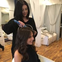 <p>A stylist at Runway Blowout Lounge gives a customer first class treatment.</p>