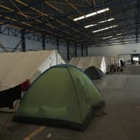 <p>Syrian refugees sleep in tents in Greek factories.</p>