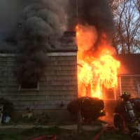 <p>The Westport Fire Department tackles a blaze at a home on Cross Highway on Monday morning.</p>
