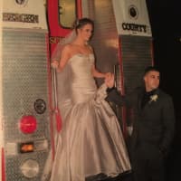 <p>Ridgefield Fire Department firefighters Danny and Joette Fugnitti pose on the engine that will soon be used to spread cancer awareness at their wedding.</p>