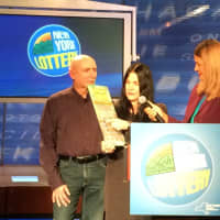 <p>Catherine Sakal, an accountant from Dutchess County, bought a winning $5 million Lottery scratch-off ticket in Rhinebeck on Jan. 4. She is shown here collecting her ceremonial check worth more than $3.3 million with her husband, William.</p>