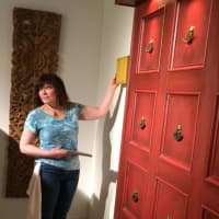 <p>Artist Nancy Eckl considers different colors for one of her headboards at I.M. Smitten Gallery of Trumbull.</p>