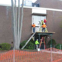 <p>Workers outside the Board of Education and District office entrance of Port Chester-Rye Union Free District on Oct. 31, 2017. Port Chester Middle School reopened on Nov. 6 after emergency repairs. Voters narrowly defeated a proposed bond project.</p>
