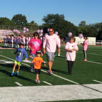 <p>Coach John VanSoest accompanies his mom, Nancy, and aunt, Joan, down the field with his two sons.</p>