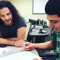 <p>Will Esposito helps Michael Serrano, a New Milford High School junior, take a personality test at HYPELITE.</p>