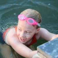 <p>Willow Phelps of Ringwood swims in Cupsaw Lake.</p>