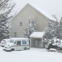 <p>Neither rain nor snow nor dark of night: A postman makes his rounds on a stormy Thursday in Trumbull.</p>