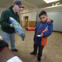 <p>District Deputy of the Connecticut State Knights of Columbus George Ribellino helps Lazandro Jaurez, 10, find a new coat during the Knights of Columbus Coats for Kids program Friday, Nov. 24, at St. Joseph Church in South Norwalk.</p>