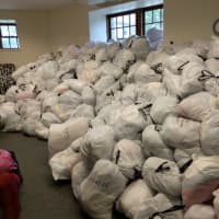 <p>Piles of donated goods placed into bags as part of an effort to help Syrian refugees.</p>