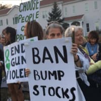 <p>A protester at a candlelight vigil in Newtown calls for a ban on bump stocks, which make a semiautomatic weapon capable of automatic weapon fire. The vigil was held at the headquarters of the National Shooting Sports Foundation on Wednesday evening.</p>
