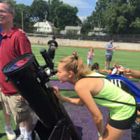 <p>Chelsea Rose of Larchmont checks out the solar eclipse on a telescope provided by New Rochelle High School.</p>
