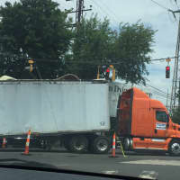 <p>A wrecked tractor-trailer blocks East Main Street in Stamford on Tuesday after crashing into a railroad bridge.</p>