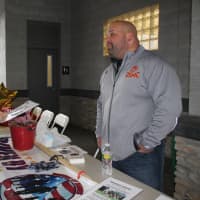 <p>Carlo Oropresa chats with Davin Lehman at his Driven By Heroes table, a service that provides non-emergency transportation to veterans. </p>