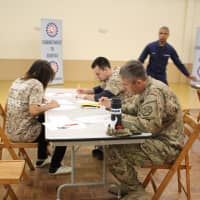 <p>Volunteers and military members from the U.S. Army and U.S. Coast Guard reviewed project forms and wrote letters to troops overseas. </p>