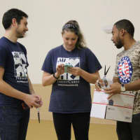 <p>From left, Evan Lewis, Kristen Coppola, both of Jersey Cares, and Phaedron Bolton, an employee of the NBA, prepare boxes for troops at the Bogota VFW. </p>
