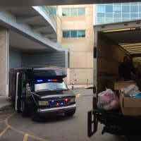 <p>A U-Haul truck and police bus await unloading at HUMC.</p>