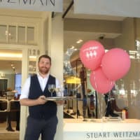 <p>Adam Gold welcomes shoppers to Stuart Weitzman with a refreshing beverage during the Go For Pink! fundraiser, Thursday, Oct. 6, 2016.</p>