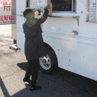 <p>Beverly Allen of New Milford purchases lunch from Mark Butlter at his Bergenfield-parked hotdog truck. </p>