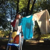 <p>Sue Horton, a member of the Trumbull Rotary Club, hangs T-shirts for The Clothesline Project.</p>