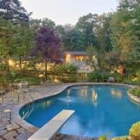 <p>The secluded, three-acre backyard has an inground pool and full tennis court.</p>