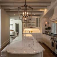 <p>The kitchen features marble countertops and custom materials.</p>