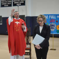 <p>The Rev. Tom Collins blesses Melissa Dan as the Holy Child community installed her as their new head of school.</p>