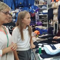 <p>Dorothy Mastropaolo from JDM Associates in Lodi helps a mother and daughter shop for uniform and accessories.</p>
